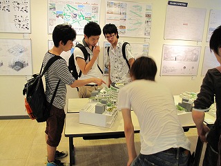 模型を前に話し込む見学者